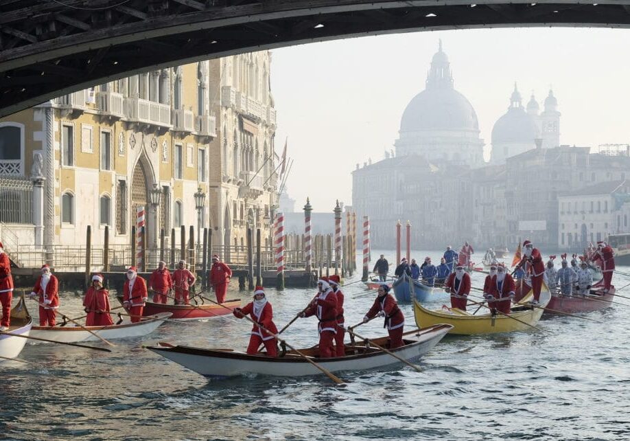 People dressed as Santa Claus row boats on Venice's Grand Canal, in northern Italy, December 20, 2015. REUTERS/Manuel Silvestri - RTX1ZGO7
